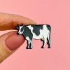 Cow-shaped pin made of tin.