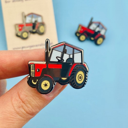 A tractor-shaped pin made of tin.